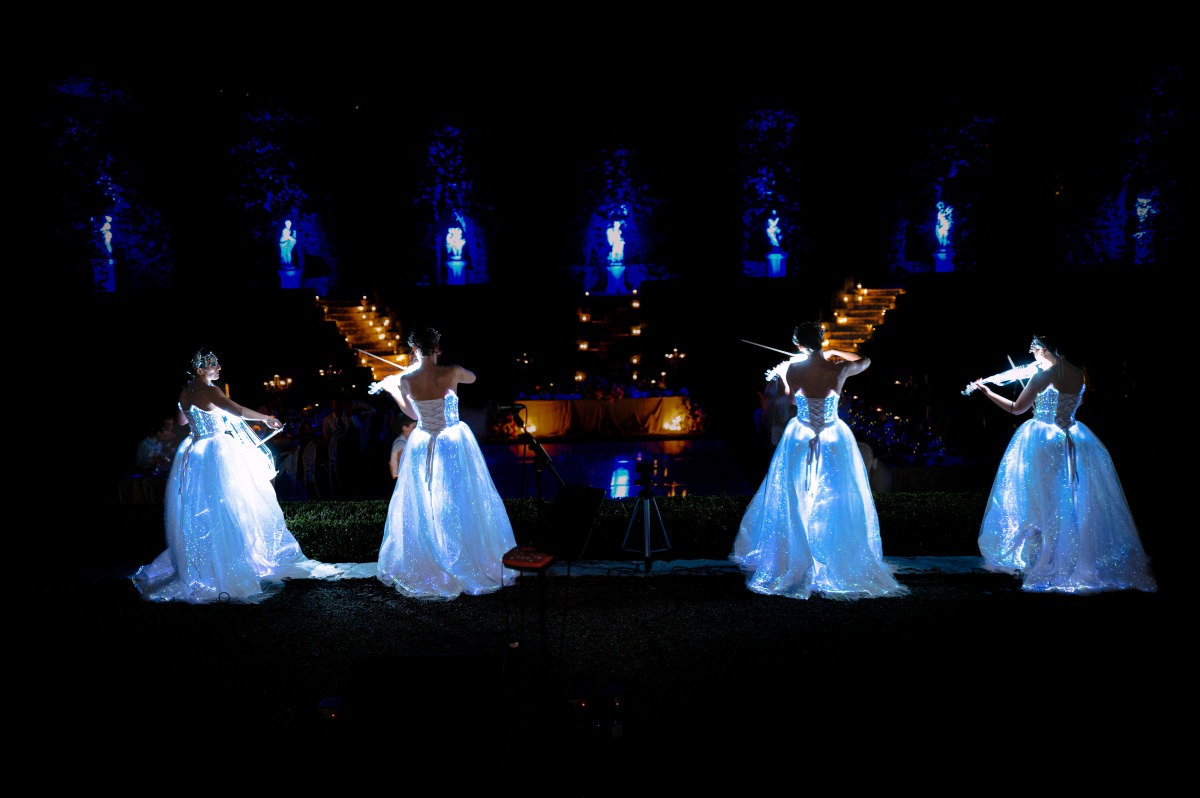 violinists in glowing dresses